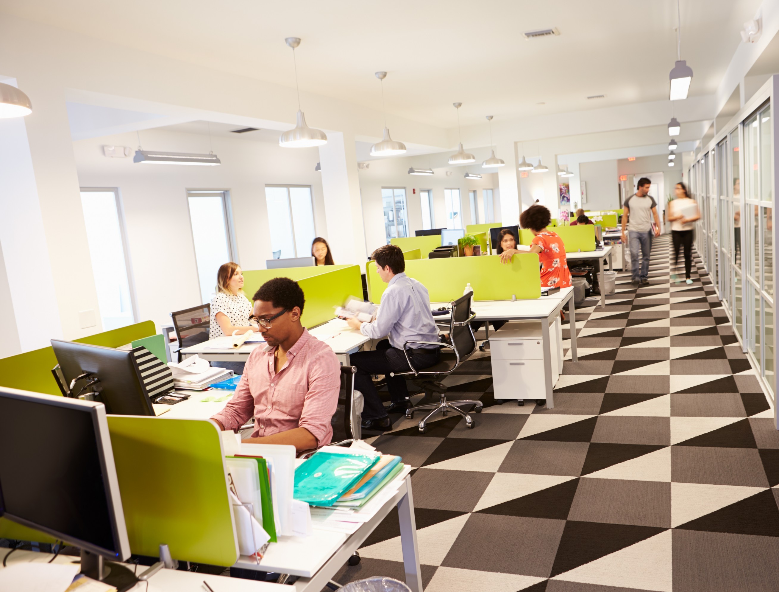 A modern office with several people at workstations.